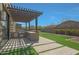 This backyard features a pergola, built in BBQ, artificial turf, and desert landscaping at 17756 E Colt Dr, Queen Creek, AZ 85142