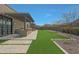 A serene backyard featuring a pergola, built in BBQ, artificial turf, and desert landscaping at 17756 E Colt Dr, Queen Creek, AZ 85142