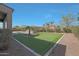 Sprawling backyard featuring a custom putting green, mature desert landscaping, and home architecture at 17756 E Colt Dr, Queen Creek, AZ 85142