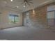 Spacious bedroom with a stone accent wall and natural light from large windows at 17756 E Colt Dr, Queen Creek, AZ 85142
