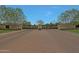 A private community gate provides security and privacy with mature shade trees lining the brick paved entry at 17756 E Colt Dr, Queen Creek, AZ 85142