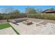 A built in gas firepit with travertine tile and desert landscaping in a backyard setting at 17756 E Colt Dr, Queen Creek, AZ 85142