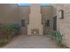 Secluded front patio with a stone fireplace, desert landscaping and an entrance to a modern, single-Gathering home at 17756 E Colt Dr, Queen Creek, AZ 85142