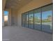 Covered patio with travertine tile and large sliding glass doors overlooking backyard at 17756 E Colt Dr, Queen Creek, AZ 85142