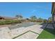 A beautiful in-ground pool with a fire feature surrounded by desert landscaping and travertine tile at 17756 E Colt Dr, Queen Creek, AZ 85142