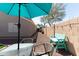 Inviting backyard featuring gravel, seating, string lights, and a turquoise umbrella for shaded relaxation at 1844 E Angelica St, Casa Grande, AZ 85122