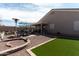 Attractive backyard with varied textures of stone, gravel, and artificial turf, complete with dining set and decor at 1844 E Angelica St, Casa Grande, AZ 85122