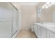 Bright bathroom featuring double sink vanity with white cabinetry and shower with glass door at 18668 N Lariat Ct, Surprise, AZ 85387