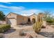 Charming single-story home with desert landscaping, including a saguaro cactus and rock accents at 18668 N Lariat Ct, Surprise, AZ 85387