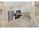 Close-up of kitchen featuring granite countertops, stainless steel refrigerator, and sleek black appliances at 18668 N Lariat Ct, Surprise, AZ 85387