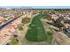 Aerial view of a well-groomed golf course bordering a neighborhood with terracotta rooftops, evoking a sense of leisure at 1960 Leisure World --, Mesa, AZ 85206
