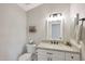 Cozy powder room with granite countertop, white cabinetry, and decorative mirror at 1960 Leisure World --, Mesa, AZ 85206