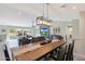 Open-concept dining area with hardwood floors, stylish lighting, and seamless flow to the living room and outdoor patio at 1960 Leisure World --, Mesa, AZ 85206