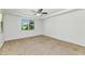 Bright bedroom with neutral carpet, a ceiling fan, and a window overlooking the yard at 2146 W Ian Dr, Phoenix, AZ 85041