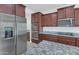 Close-up of a kitchen with stainless appliances, granite counters, and dark wood cabinetry at 2146 W Ian Dr, Phoenix, AZ 85041