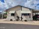 Charming manufactured home with desert landscaping, carport, and neutral color scheme under cloudy skies at 2460 E Main St # A2, Mesa, AZ 85213