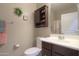 Well-lit bathroom with a vanity, toilet, and a decorative cabinet above at 2611 E San Simeon Dr, Casa Grande, AZ 85194