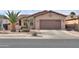Charming single-story home with well-maintained landscaping and a brown two-car garage at 2611 E San Simeon Dr, Casa Grande, AZ 85194