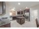 Modern kitchen features stainless steel appliances, dark cabinets, and an island with granite counters at 2611 E San Simeon Dr, Casa Grande, AZ 85194