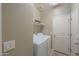 Functional laundry room with washer, dryer, storage shelf, and ample space at 2611 E San Simeon Dr, Casa Grande, AZ 85194