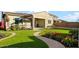 Charming backyard with lush green lawn, pathway and patio sitting area at 26844 N 73Rd Dr, Peoria, AZ 85383