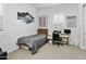 Well-lit bedroom with sports decor, featuring a comfortable bed, a modern desk, and bright natural light at 26844 N 73Rd Dr, Peoria, AZ 85383