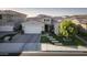 Charming front elevation showcasing a well-manicured lawn, stepping stone path, and an inviting two-car garage at 26844 N 73Rd Dr, Peoria, AZ 85383