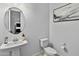 A stylish powder room featuring a pedestal sink, modern fixtures, and a neutral color palette at 26844 N 73Rd Dr, Peoria, AZ 85383