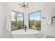 Bright bathroom with a modern tub and serene desert views from large black-framed windows at 30600 N Pima Rd # 76, Scottsdale, AZ 85266