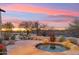 Relaxing outdoor hot tub with stone accents and lush desert landscaping under a colorful sky at 30600 N Pima Rd # 76, Scottsdale, AZ 85266