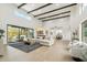 Bright living room featuring soaring ceilings, wood beams, and open floor plan connecting the living space and kitchen at 30600 N Pima Rd # 76, Scottsdale, AZ 85266