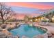 Stunning backyard with a lagoon-style pool, lounge chairs, desert landscaping, and beautiful sunset views at 30600 N Pima Rd # 76, Scottsdale, AZ 85266