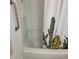 Bright white bathtub features a cactus-themed shower curtain and accessible grab bar for added safety and convenience at 311 E Lancaster Ct, Florence, AZ 85132