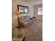 Cozy living room with neutral carpet, accent lamp, and large mirror, creating a comfortable space at 311 E Lancaster Ct, Florence, AZ 85132