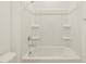 White bathtub with chrome fixtures in a bright bathroom with tiled walls at 318 S San Fernando Ln, Casa Grande, AZ 85194