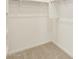 Bright walk-in closet with a carpeted floor and custom shelving and hanging system at 318 S San Fernando Ln, Casa Grande, AZ 85194