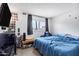 This charming bedroom has a blue quilt, dark curtains, and a window at 3222 W Hearn Rd, Phoenix, AZ 85053