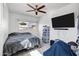 Cozy bedroom with a ceiling fan, television, and window providing natural light at 3222 W Hearn Rd, Phoenix, AZ 85053