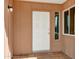 Close-up of the front door entrance featuring a white door and a side window on a tile porch at 3222 W Hearn Rd, Phoenix, AZ 85053