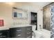 Well-lit bathroom featuring dark wood cabinetry, a tiled shower, and modern fixtures at 3514 W Charleston Ave, Glendale, AZ 85308