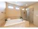 Bright bathroom featuring a soaking tub, walk-in shower, and neutral tiling at 36600 N Cave Creek Rd # 17D, Cave Creek, AZ 85331