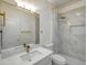 Modern bathroom featuring white fixtures, a marble shower, and gold accents at 3918 E Carson Rd, Phoenix, AZ 85042