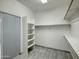 Walk-in closet with custom shelving and light gray wood-style tile floors at 3918 E Carson Rd, Phoenix, AZ 85042
