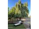Serene backyard retreat with artificial grass, gravel accents, mature shade trees, and a lounge chair at 4130 N 4Th Ave, Phoenix, AZ 85013
