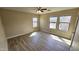 Bright bedroom featuring three windows, wood-look floors and a ceiling fan at 4908 N 110Th Dr, Phoenix, AZ 85037