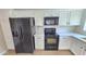 Kitchen featuring modern black appliances, white cabinets, and countertops at 4908 N 110Th Dr, Phoenix, AZ 85037