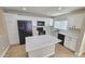 Well-lit kitchen with modern black appliances, white cabinets, and a center island at 4908 N 110Th Dr, Phoenix, AZ 85037