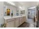A bathroom features a double sink vanity, wood-look floors, and an open doorway to the primary bedroom at 5450 E Mclellan Rd # 102, Mesa, AZ 85205