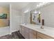 A well-lit bathroom featuring a double sink vanity, a separate shower, and wood-look floors at 5450 E Mclellan Rd # 102, Mesa, AZ 85205