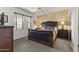 A Primary bedroom featuring an upholstered headboard, bedside tables with lamps, and a textured accent wall at 5450 E Mclellan Rd # 102, Mesa, AZ 85205